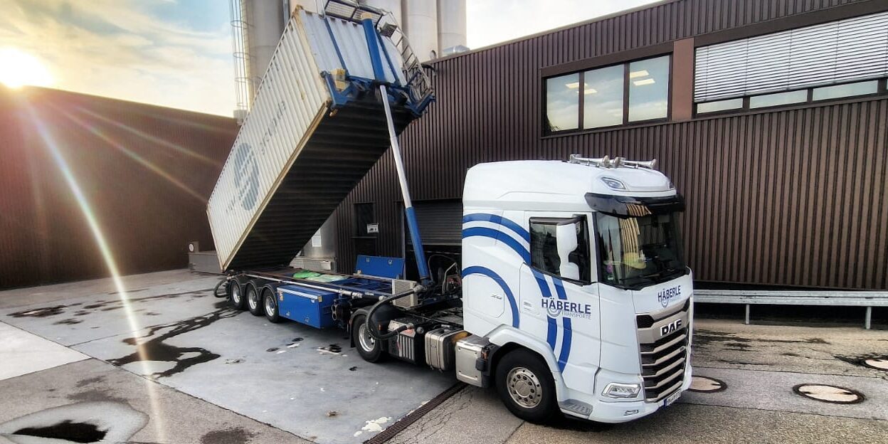 Ein Weißer Häberle Lkw mit Container.